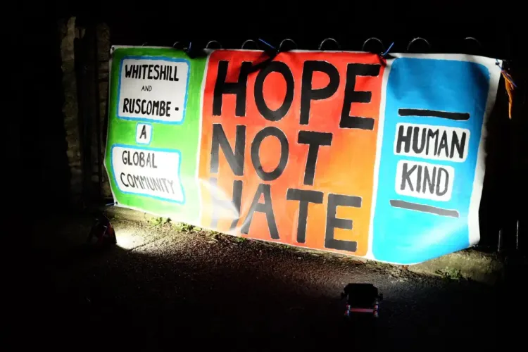 "Whiteshill and Ruscombe - A Global community", "Hope Not Hate",  "Human Kind" on a multicoloured banner